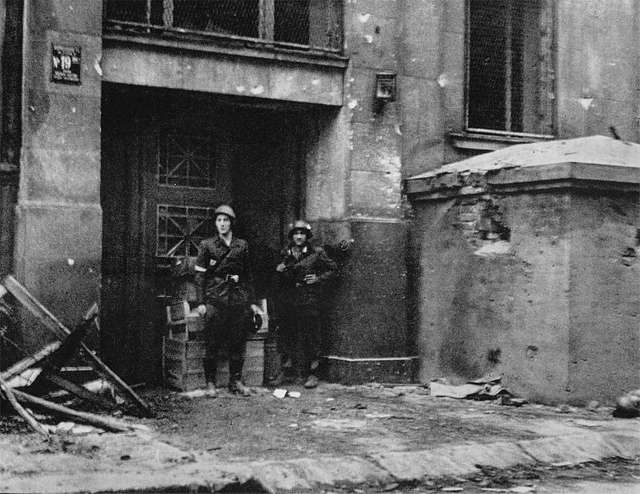 Żołnierze pod zniszczonym budynkiem